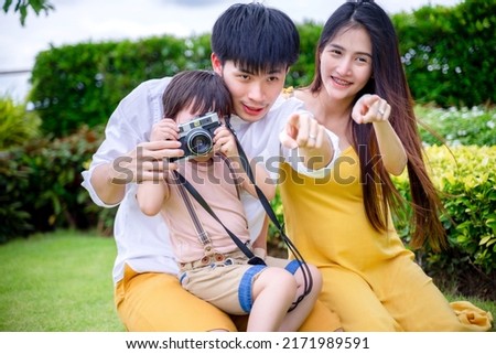 little boy taking photo with mom and dad, happy family.