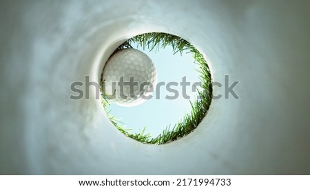 Detail of golf ball, view from inside the hole. Ultimate perspective, real shot. Concept of success and goal.