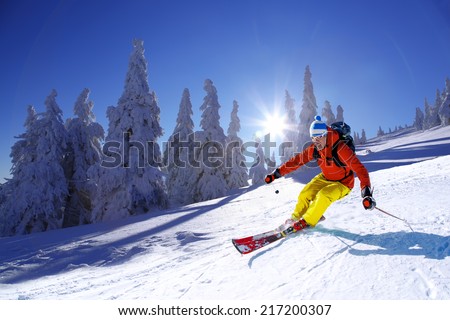 Skier skiing downhill in high mountains against sunshine Royalty-Free Stock Photo #217200307