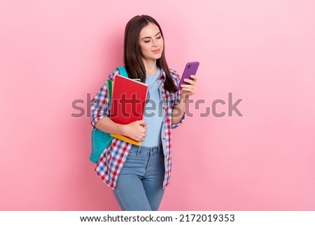 Photo of intelligent clever girl university student chatting in telephone go to campus isolated on pink color background