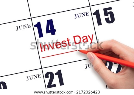 14th day of June. Hand drawing red line and writing the text Invest Day on calendar date June 14.  Business and financial concept. Summer month, day of the year concept.