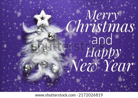 Greeting card Merry Christmas and Happy New Year. Christmas tree made of white feathers with silver balls on a very peri purple background. top view. 