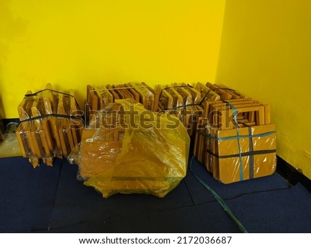 a picture of a pile of packages containing study tables collected in the corner of the room. creative background template.