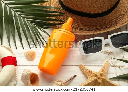 Beach flat lay accessories. Sun hat, palm branch, sunscreen bottle and seashells. Summer travel holiday concept. Top view