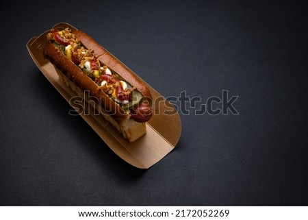 Hot dogs in paper plates with sausages and sauce 

