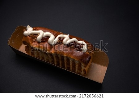 Hot dogs in paper plates without sausages. With sauce. On a black background

