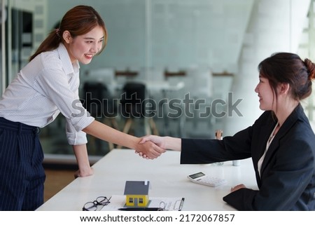 Portrait of a real estate agent shaking hands with customers to congratulate them on signing contracts to purchase house. agreement, insurance and deals concept