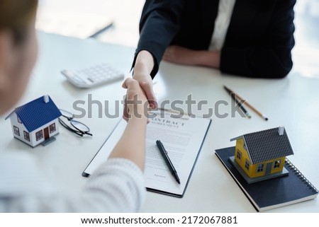 real estate agent shaking hands with customers to congratulate them on signing contracts to purchase house. agreement, insurance and deals concept