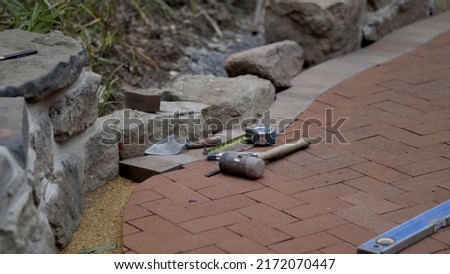 Closeup of the brick paving project showing the bricks in a herringbone pattern and the sand. Royalty-Free Stock Photo #2172070447