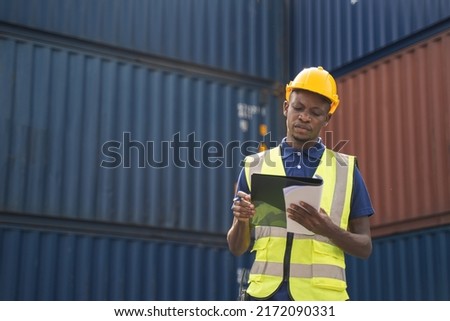 Happy African worker smailing, standing in the container workplace and crossed arms with feeling happiness Royalty-Free Stock Photo #2172090331