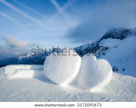 Two big hearts made of snow in the beautiful mountains. Royalty-Free Stock Photo #2172095673