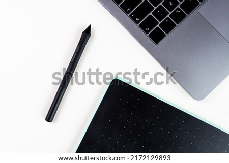 White office desk with graphic pen, tablet and laptop. Selective focus.