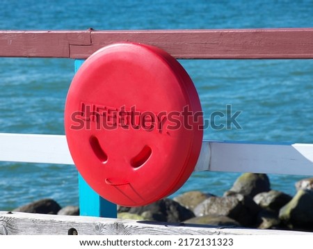 Lifebuoy on the railing of the pier by the sea.