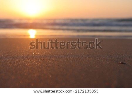 Sea waves and warm sunset light, calm and relaxing sandy beach