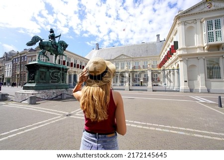 Tourism in Holland. Back view of young tourist woman visiting Noordeinde Palace in The Hague, Netherlands.