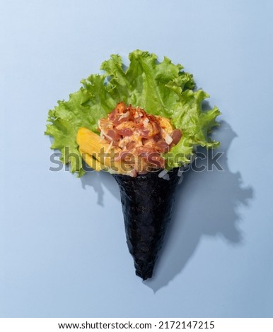 Spicy TAMAGO wrap topping with salad leaves isolated on sky blue background top view fast food