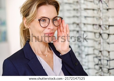 Satisfied client choose glasses in the ophthalmic store Royalty-Free Stock Photo #2172147525