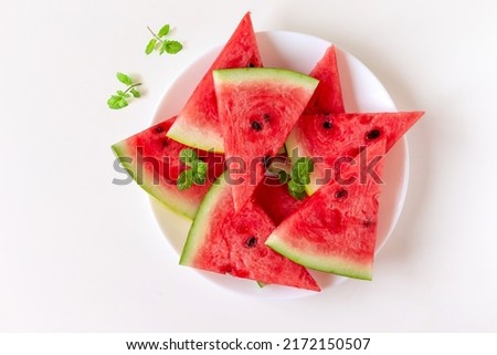 Juicy fresh nutritious watermelon on a plate with mint leaves on the side, healthy eating habit Royalty-Free Stock Photo #2172150507