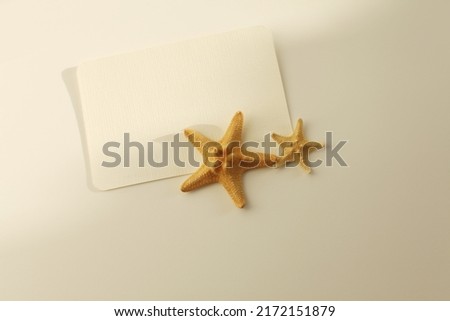 Empty Blank texture paper card with starfish and copy space for your text message. Light and shadows minimalism style template horizontal background. Flat lay, top view. Beige color tone.
