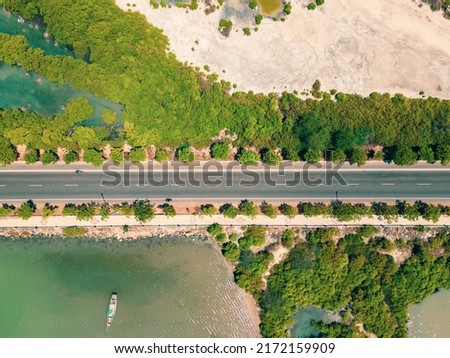 drone shot aerial view top angle bright sunny day beautiful seascape coastal area beaches forest trees turquoise blue water tourism destination India tamilnadu road highway boat sea ocean 