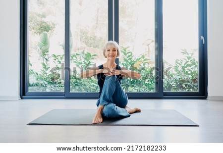 Yoga at home. Senior woman exercising indoor. Concept of healthy lifestyle. Royalty-Free Stock Photo #2172182233