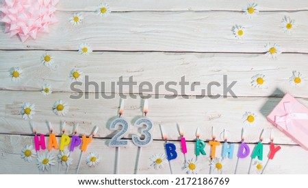 A beautiful card for a birthday in pastel colors in pink shades with a number 23. The decorations of their candles are festive from above, for a couple or a woman with a happy birthday copy space
