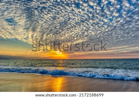 An Ocean Landscape Wit A Sky Full Of Patterned Clouds At Sunset