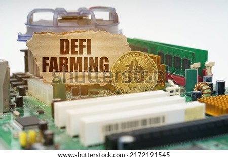 Crypto - business concept. On the motherboard lies a bitcoin coin and a cardboard sign with the inscription - DEFI farming
