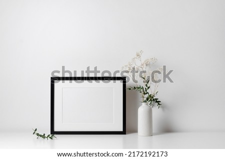 Horizontal frame mockup in white minimalistic interior with flowers decorations Royalty-Free Stock Photo #2172192173
