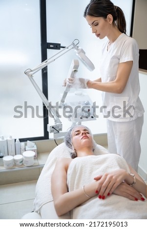 Beautiful woman on ozone therapy with facial steamer in beauty salon. Royalty-Free Stock Photo #2172195013