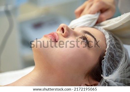 Close up head photo of beautiful woman receiving rejuvenation treatment in beauty clinic.