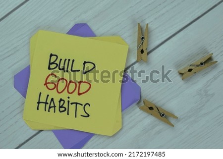 Concept of Build Good Habits write on sticky notes isolated on Wooden Table.