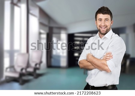 Happy mature male business leader standing at office window. Job success concept