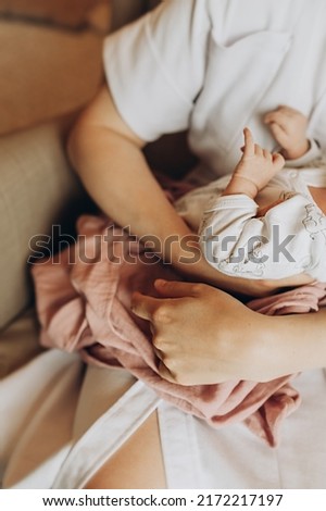 selective focus mom's hands gently hold the newborn baby. unrecognizable faces. beige tones. a gentle image.