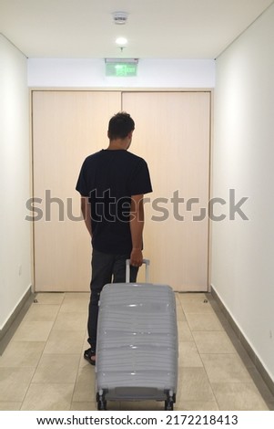 A young Russian man going away with suitcase. Russian emigration concept Royalty-Free Stock Photo #2172218413