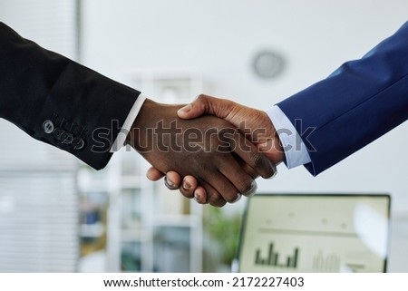 Close up of two business people shaking hands after successful partnership negotiation in office Royalty-Free Stock Photo #2172227403