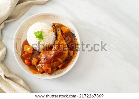homemade chicken stew with tomatoes, onions, carrot and potatoes on plate with rice Royalty-Free Stock Photo #2172267369