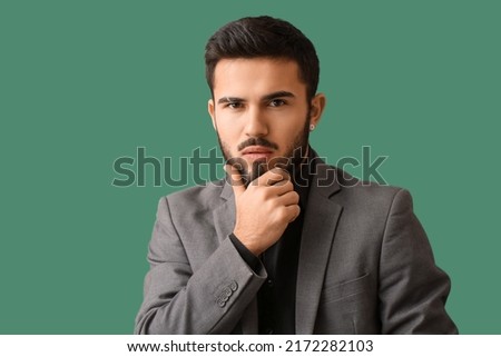 Pensive bearded man on green background
