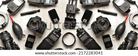 Modern photographer's equipment on light background, top view