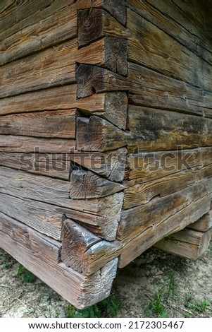 The corner of a house made of wooden logs, the corner joint of a chopped log house.Rustic log cabin wood building structure homestead historic site texture background .