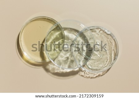 Various cosmetic products in Petri dishes on beige background view from above Royalty-Free Stock Photo #2172309159