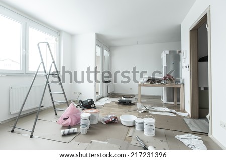 Home renovation in room full of painting tools Royalty-Free Stock Photo #217231396