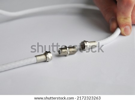 Coaxial cables connection, TV cable connector.Repairman connecting two coaxial TV cables. Royalty-Free Stock Photo #2172323263