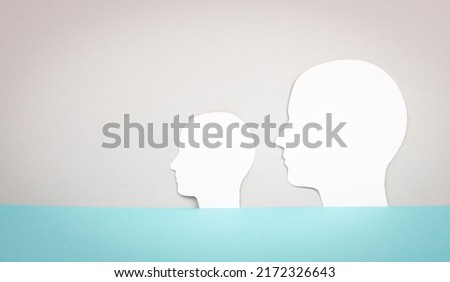 Two silhouette faces looking to the same direction, copy space for text, adult and child, profil of men, communication concept