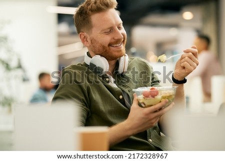 Happy businessman having a healthy meal during lunch break at work. Royalty-Free Stock Photo #2172328967