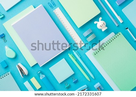 Back to school concept. Top view photo of colorful notepads bunny shaped sharpener adhesive tape binder clips marker pens erasers ruler stapler paper sticky notes correctors isolated blue background
