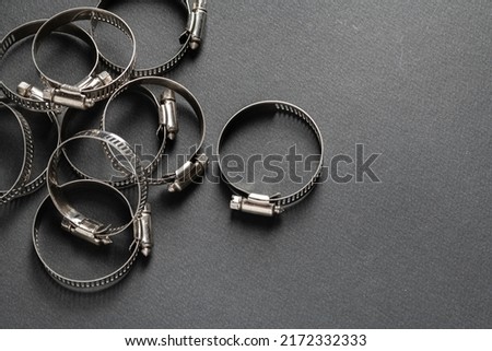 Metal hose clamp on black background. Empty space for text Royalty-Free Stock Photo #2172332333
