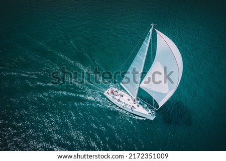 Regatta sailing ship yachts with white sails at opened sea. Aerial view of sailboat in windy condition. Royalty-Free Stock Photo #2172351009