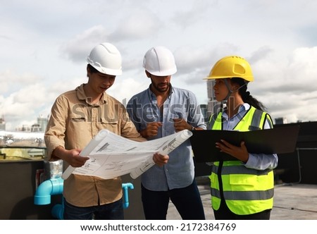 Chief engineer and site engineer working together on rooftop of new  building. Project engineer team discussing on the drawing at site line Royalty-Free Stock Photo #2172384769