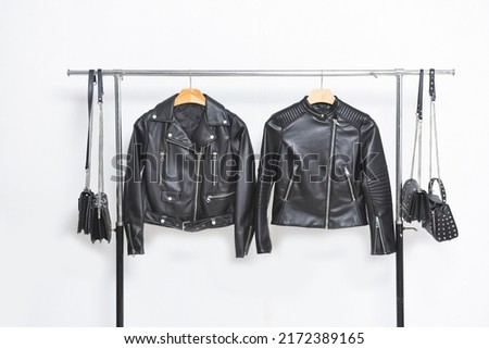 fashion two leather jacket black clothes on hanger with four handbag Royalty-Free Stock Photo #2172389165